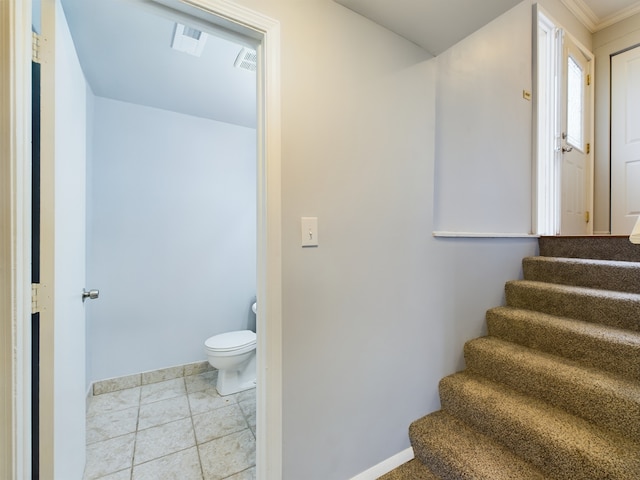 stairway with tile patterned flooring and crown molding