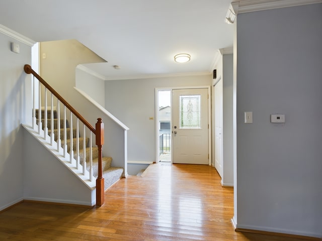 foyer with crown molding and light wood-type flooring