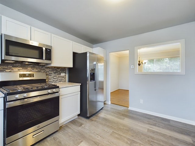 kitchen with appliances with stainless steel finishes, light hardwood / wood-style floors, white cabinetry, and tasteful backsplash