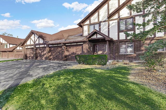 tudor house featuring a front yard and a garage