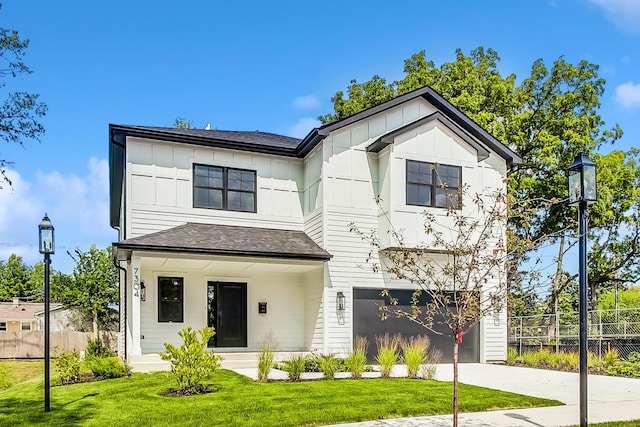 modern inspired farmhouse featuring board and batten siding, a front yard, fence, a garage, and driveway