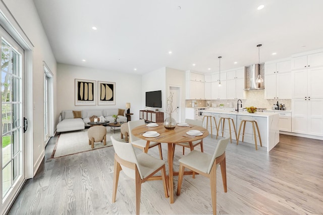 dining space with light wood-style flooring and recessed lighting