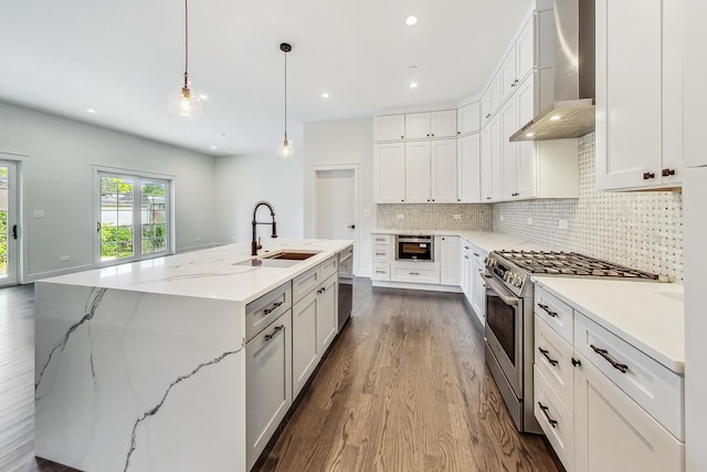 kitchen featuring a spacious island, white cabinetry, stainless steel appliances, and a sink