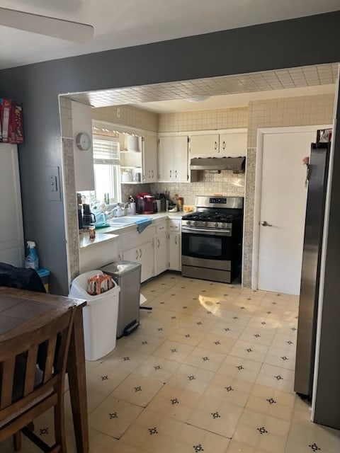 kitchen featuring white cabinets, appliances with stainless steel finishes, and backsplash