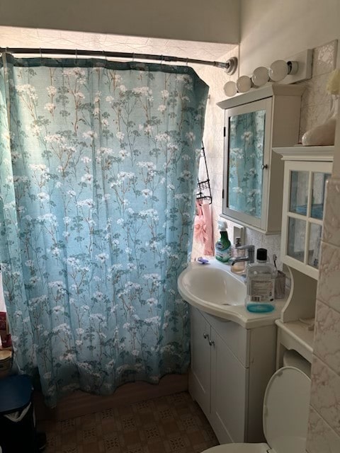 bathroom featuring vanity, toilet, and walk in shower