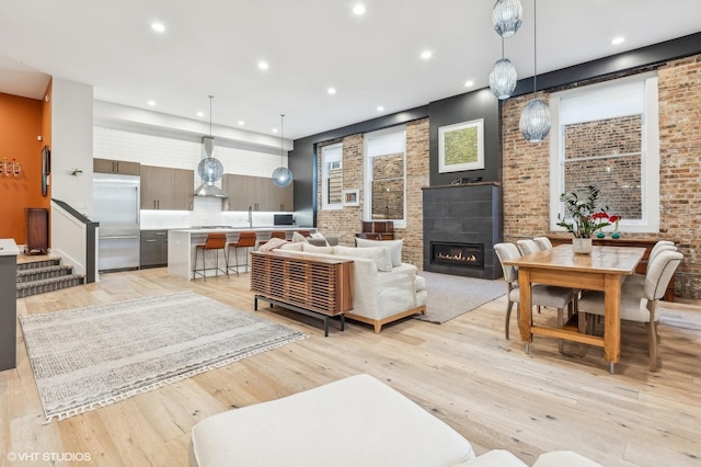 living room featuring a fireplace, light wood-type flooring, and sink