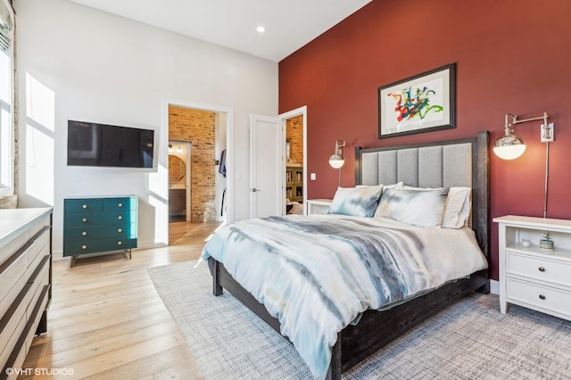 bedroom featuring ensuite bathroom and light hardwood / wood-style flooring