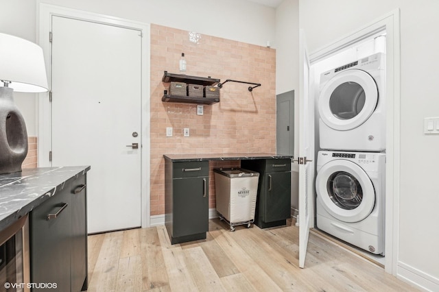 laundry room with stacked washer / drying machine, wine cooler, and light hardwood / wood-style flooring