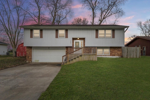 raised ranch with a garage and a yard