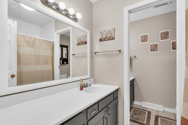 bathroom with tile patterned flooring, vanity, and toilet