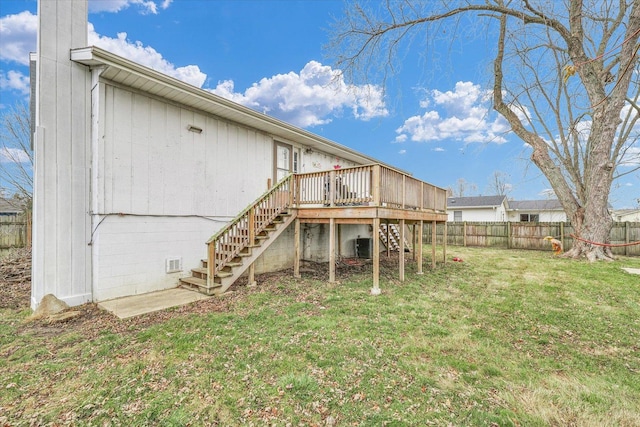 rear view of property with a yard, cooling unit, and a deck