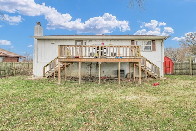 rear view of property featuring a storage unit, central AC, a lawn, and a wooden deck