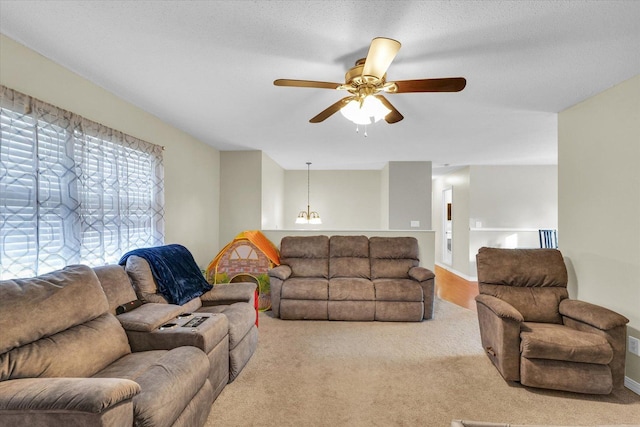 living room with ceiling fan, light colored carpet, and a textured ceiling