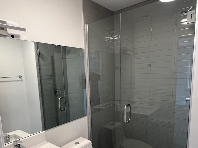 bathroom with toilet and a shower with shower door