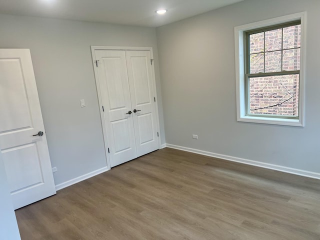 unfurnished bedroom with hardwood / wood-style floors and a closet