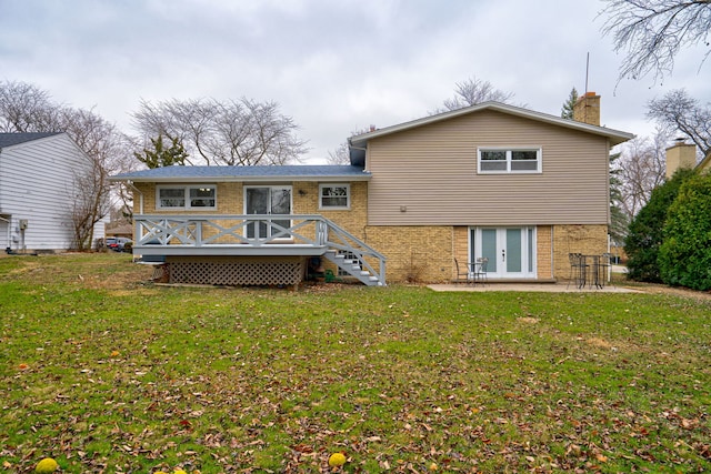 rear view of property featuring a lawn, french doors, a patio, and a deck