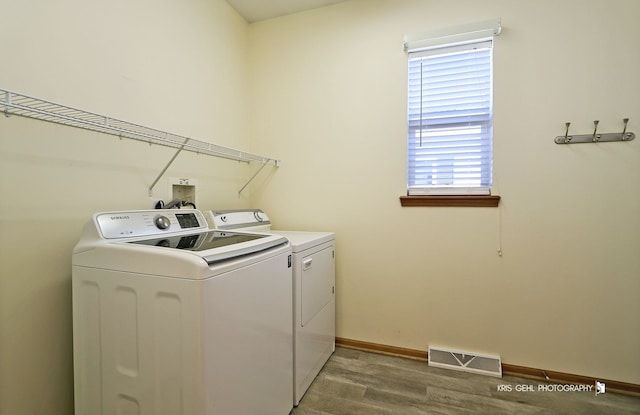 laundry area featuring independent washer and dryer and hardwood / wood-style flooring