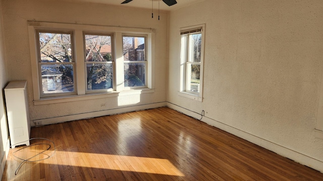 spare room with hardwood / wood-style flooring and ceiling fan