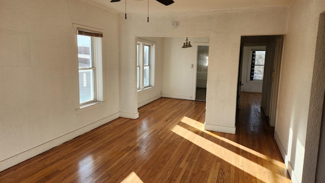 empty room with ceiling fan and hardwood / wood-style flooring