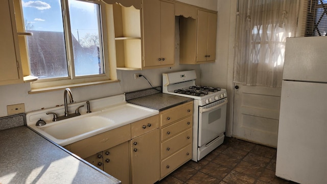 kitchen featuring cream cabinetry, white appliances, and sink