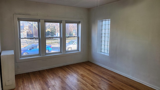 unfurnished room with wood-type flooring