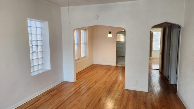 empty room featuring plenty of natural light and hardwood / wood-style floors