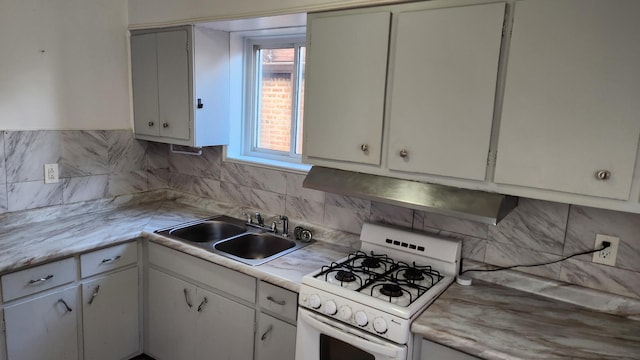 kitchen featuring white range with gas stovetop, range hood, white cabinetry, and sink