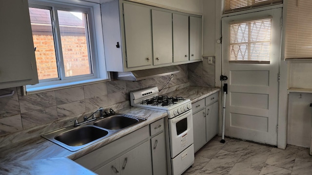 kitchen with white range with gas cooktop, decorative backsplash, and sink