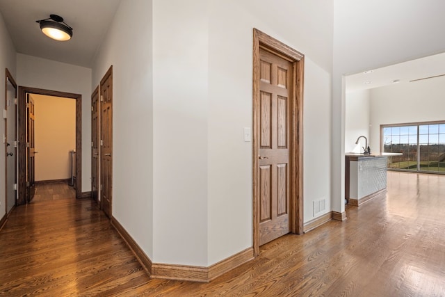 corridor featuring dark hardwood / wood-style flooring and sink