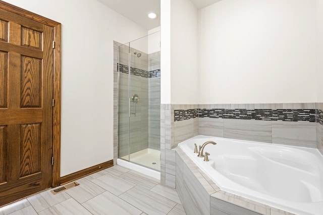 bathroom with tile patterned floors and shower with separate bathtub