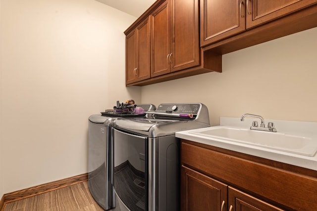 laundry room featuring cabinets, separate washer and dryer, and sink