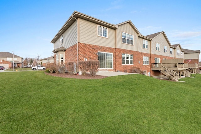 back of property featuring a wooden deck, a patio area, and a yard