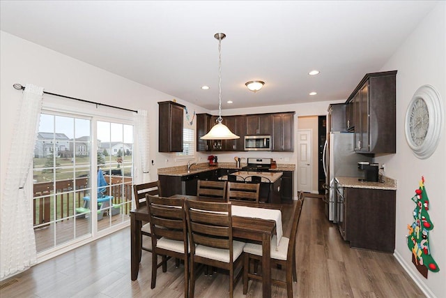 dining area featuring sink and dark wood-type flooring