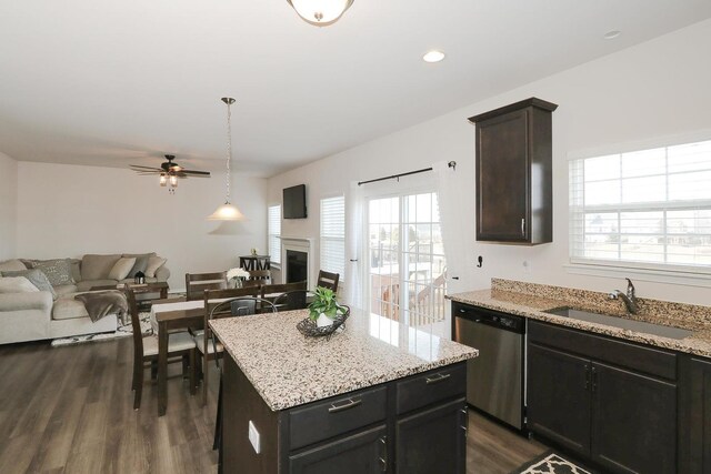 kitchen featuring appliances with stainless steel finishes, sink, a center island, dark brown cabinetry, and dark wood-type flooring