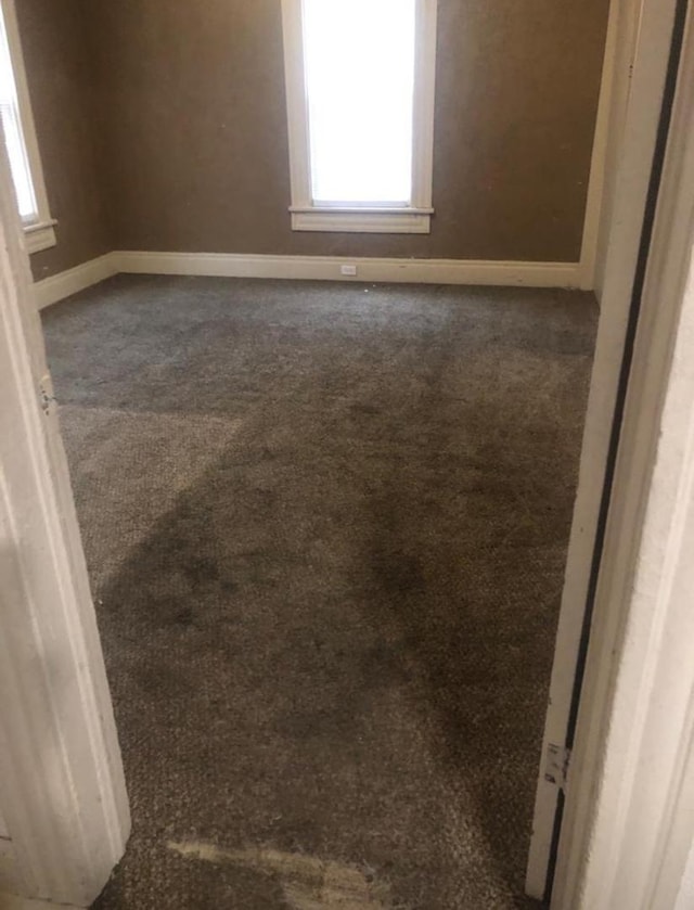 spare room with dark carpet