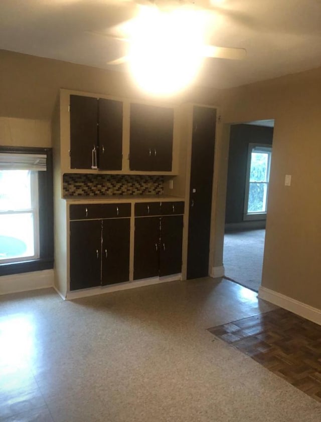 interior space with ceiling fan, a healthy amount of sunlight, and backsplash