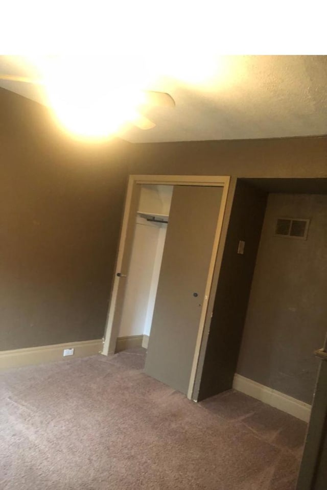 unfurnished bedroom featuring carpet flooring and a closet