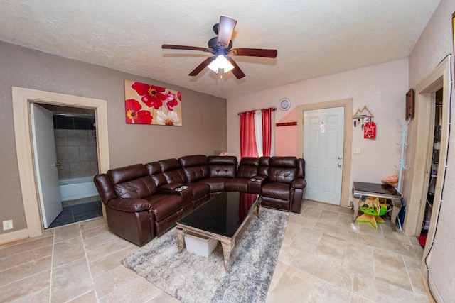 living room with ceiling fan and a textured ceiling