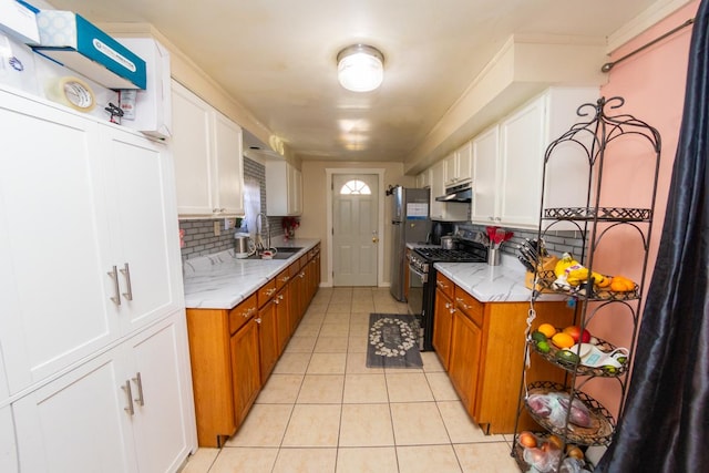 kitchen featuring decorative backsplash, light tile patterned flooring, black gas stove, and white cabinetry