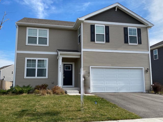 view of front of property featuring a front yard and a garage