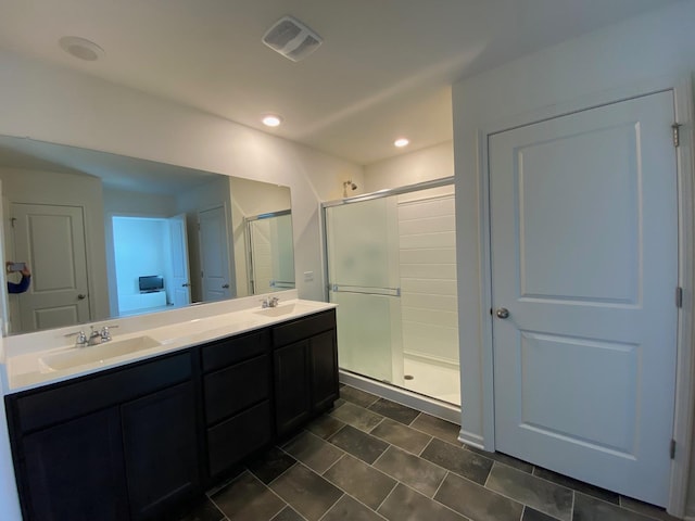 bathroom with vanity and a shower with door