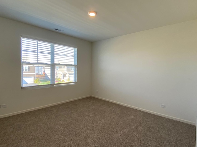 unfurnished room featuring dark colored carpet