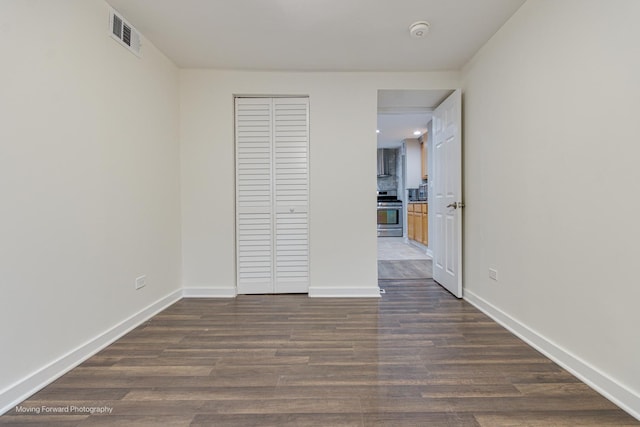 unfurnished bedroom featuring dark hardwood / wood-style flooring and a closet