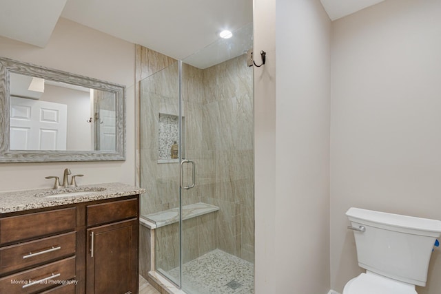 bathroom featuring vanity, toilet, and walk in shower