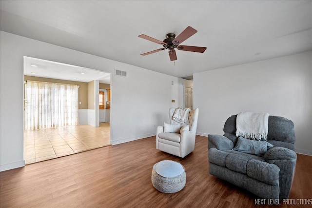 living area featuring wood-type flooring and ceiling fan