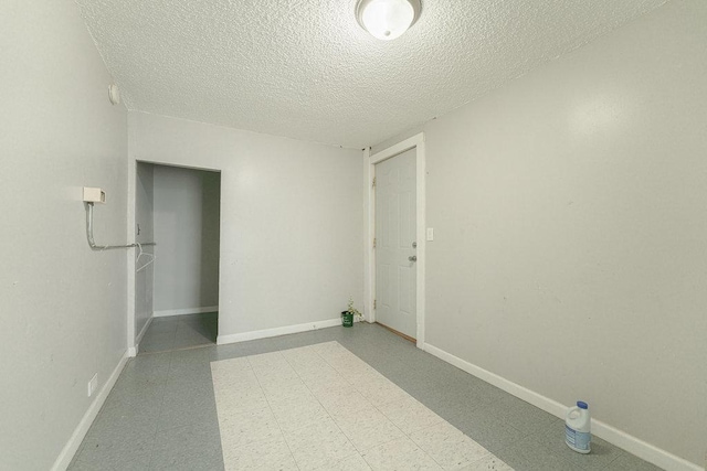 unfurnished room featuring a textured ceiling