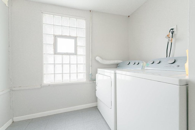 washroom featuring washer and clothes dryer and light tile patterned flooring