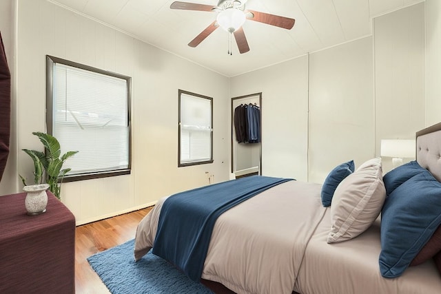 bedroom with ceiling fan, light hardwood / wood-style floors, and crown molding