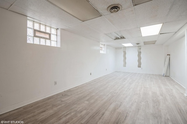 basement with hardwood / wood-style floors and a drop ceiling