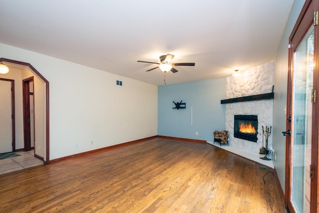 unfurnished living room with hardwood / wood-style floors, a fireplace, and ceiling fan